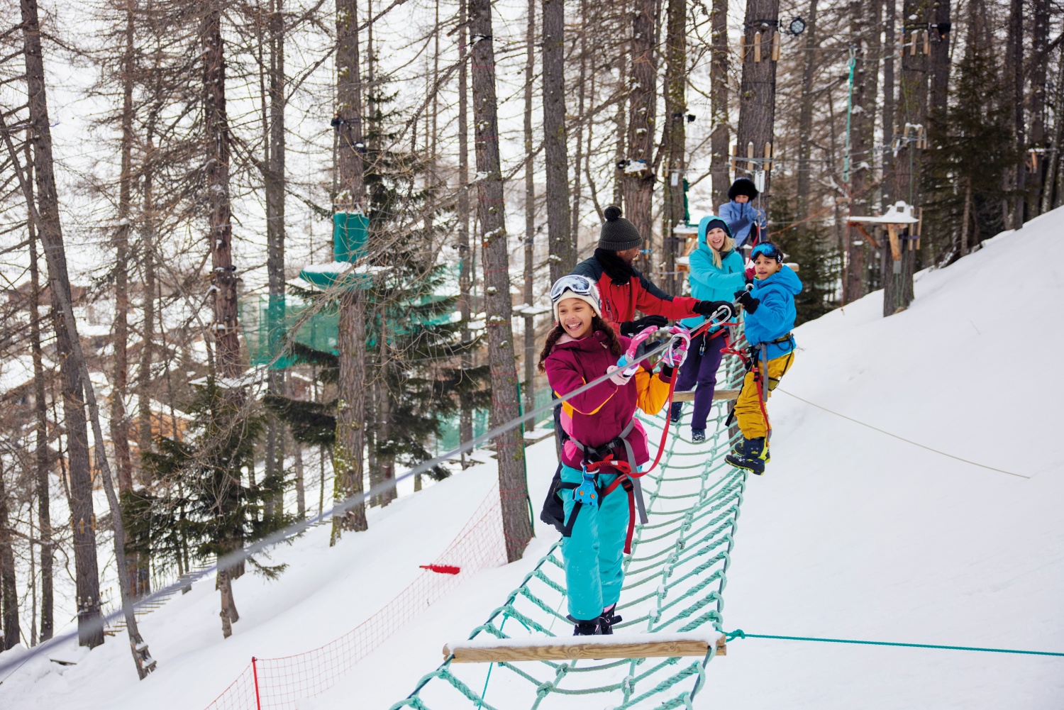 Family on snowy climbing frame