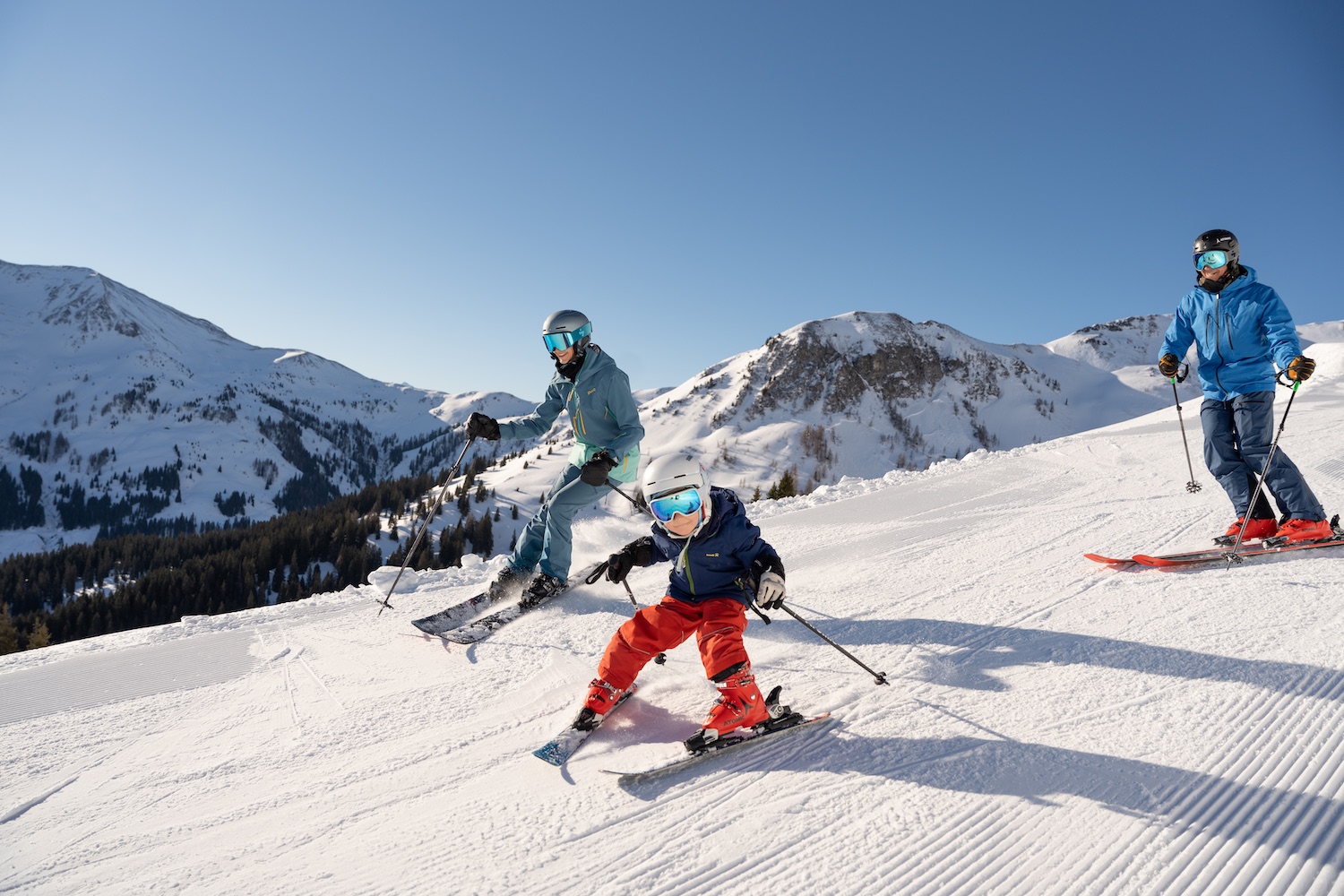 Family skiing down slopes, Saalbach Hinterglemm Leogang Fieberbrunn 