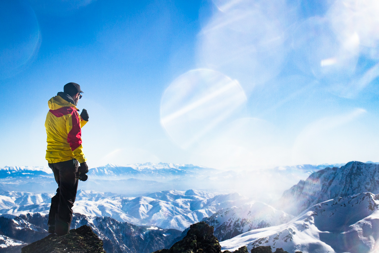 Man looking out over snowy mountains