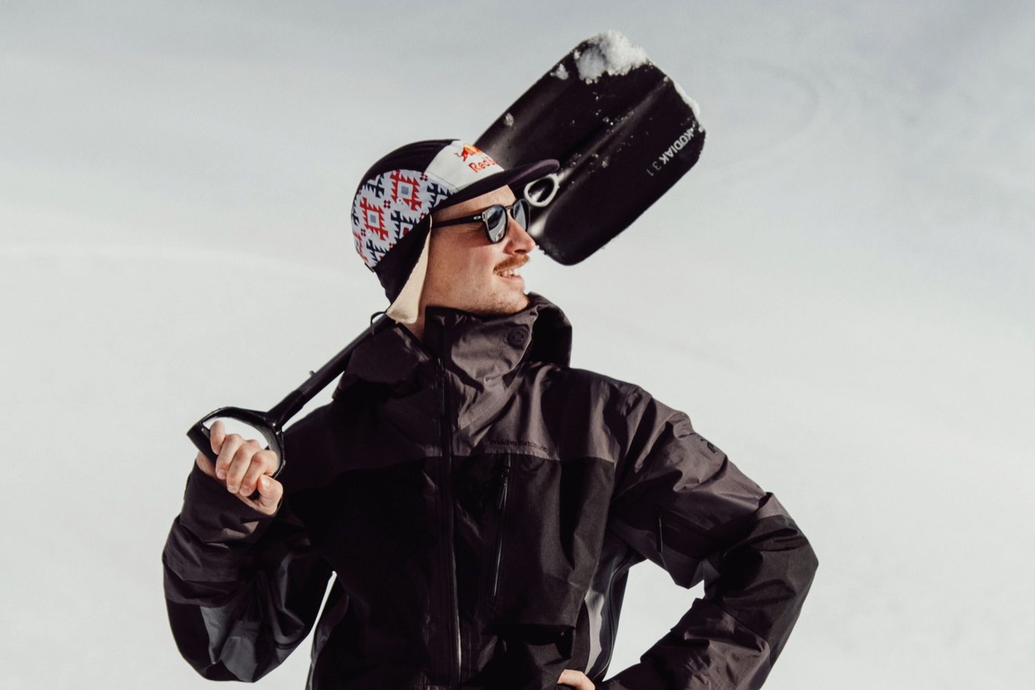 Man posing with snow spade wearing snow apparel