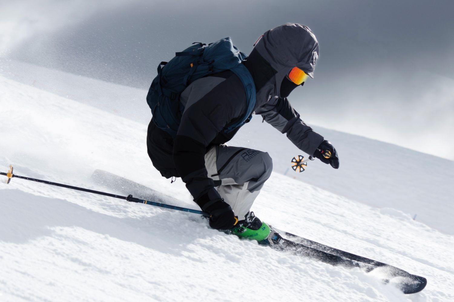 Man skiing down slope wearing full ski gear