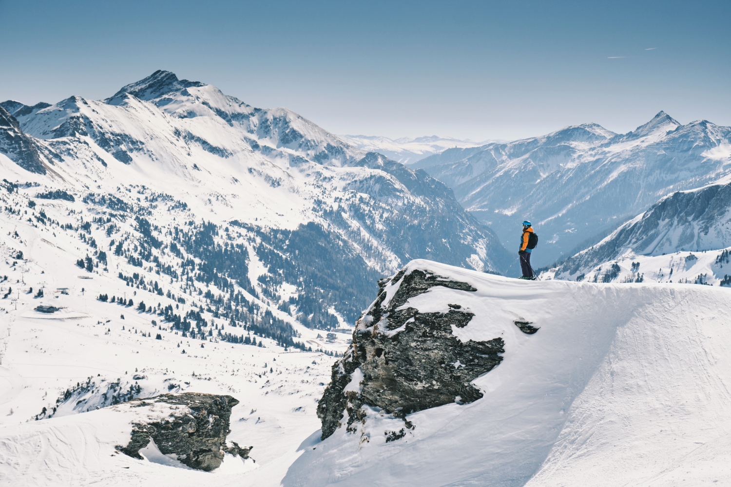 Skier looking out at snowy mountains