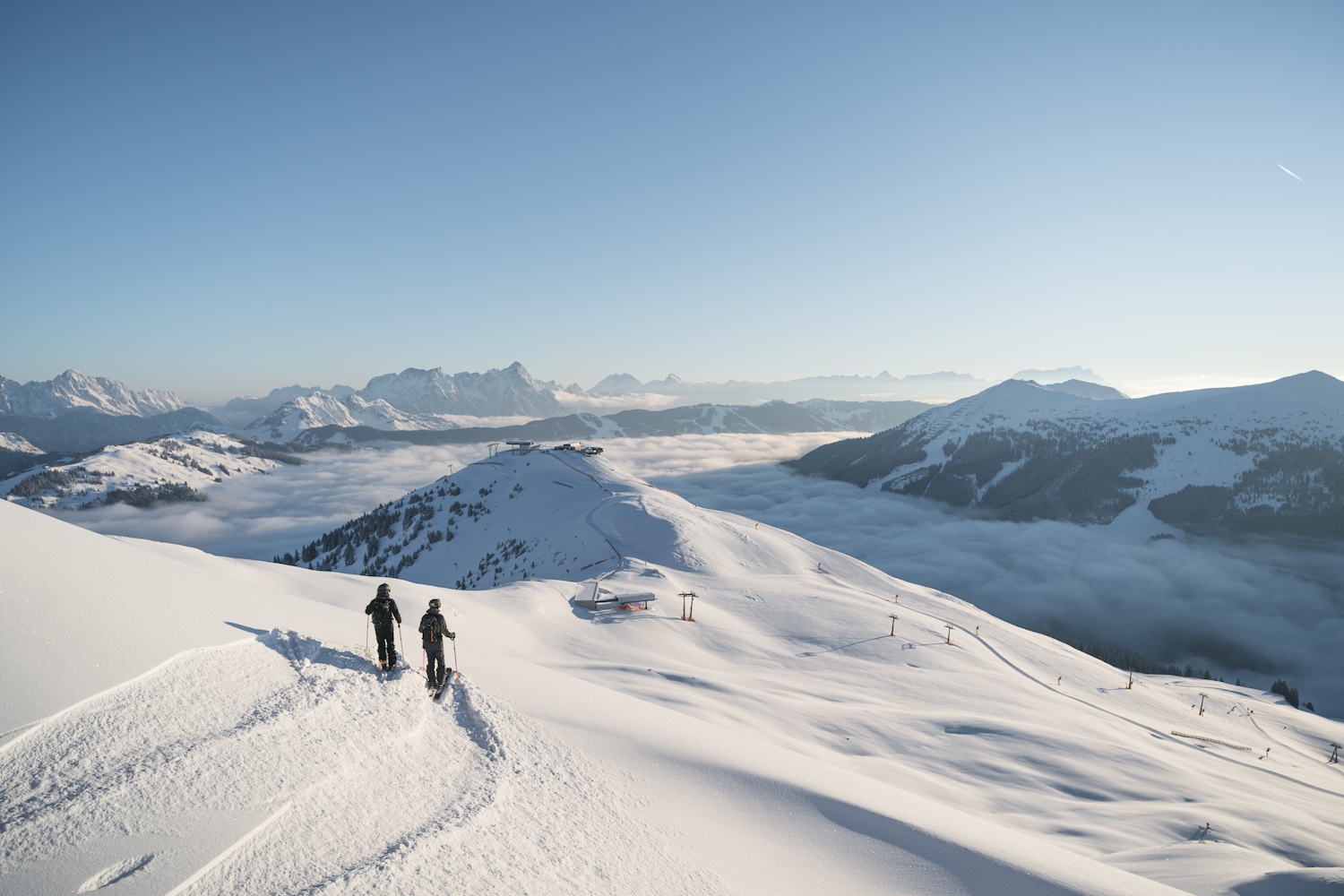 Skiers looking out across snowing mountainscape, Skicircus Saalbach Hinterglemm Leogang Fieberbrunn