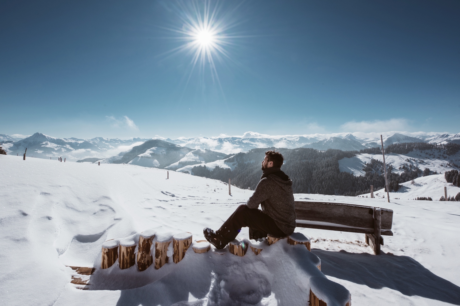 Man sat enjoy view of snow covered mountains, SkiWelt