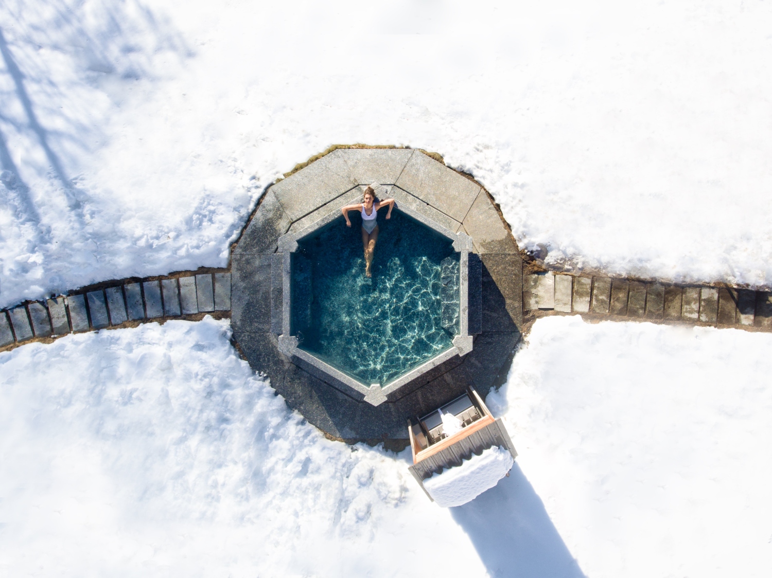 Woman in pool surrounded by snow in Bormio
