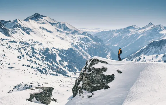 Skier looking out at snowy mountains SalzburgerLand CREDIT Daniel Wildey