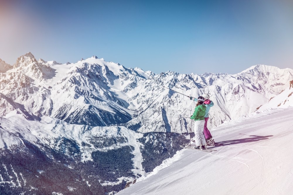 skiers looking out ober the beautiful swiss alps