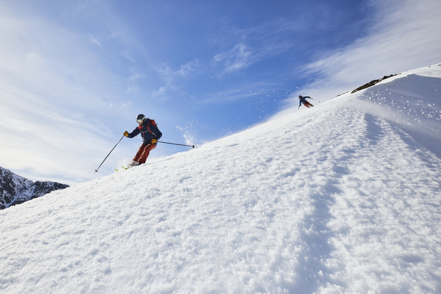 Low angle shot of skiers coming down slope, Scotland