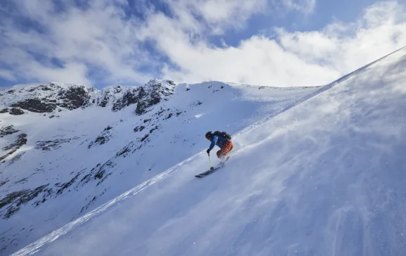 Skier riding down slope with snow blowing across plain Scottish Ski Touring CREDIT EdSmith WildSki22 HighRes 42