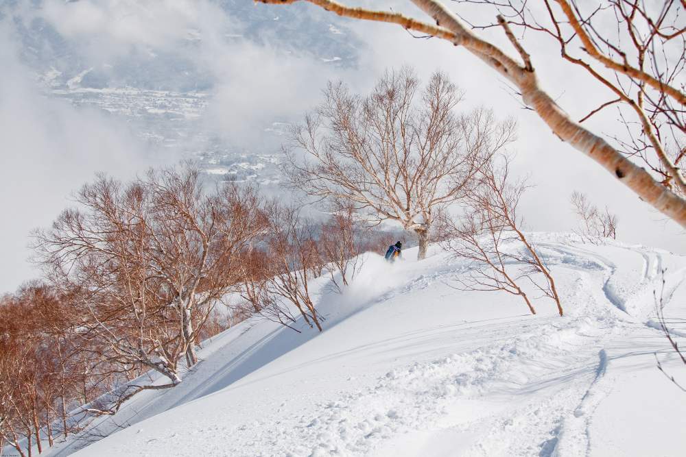 Pete Coombs Snowboarding a ridge line in Akukura Onsen