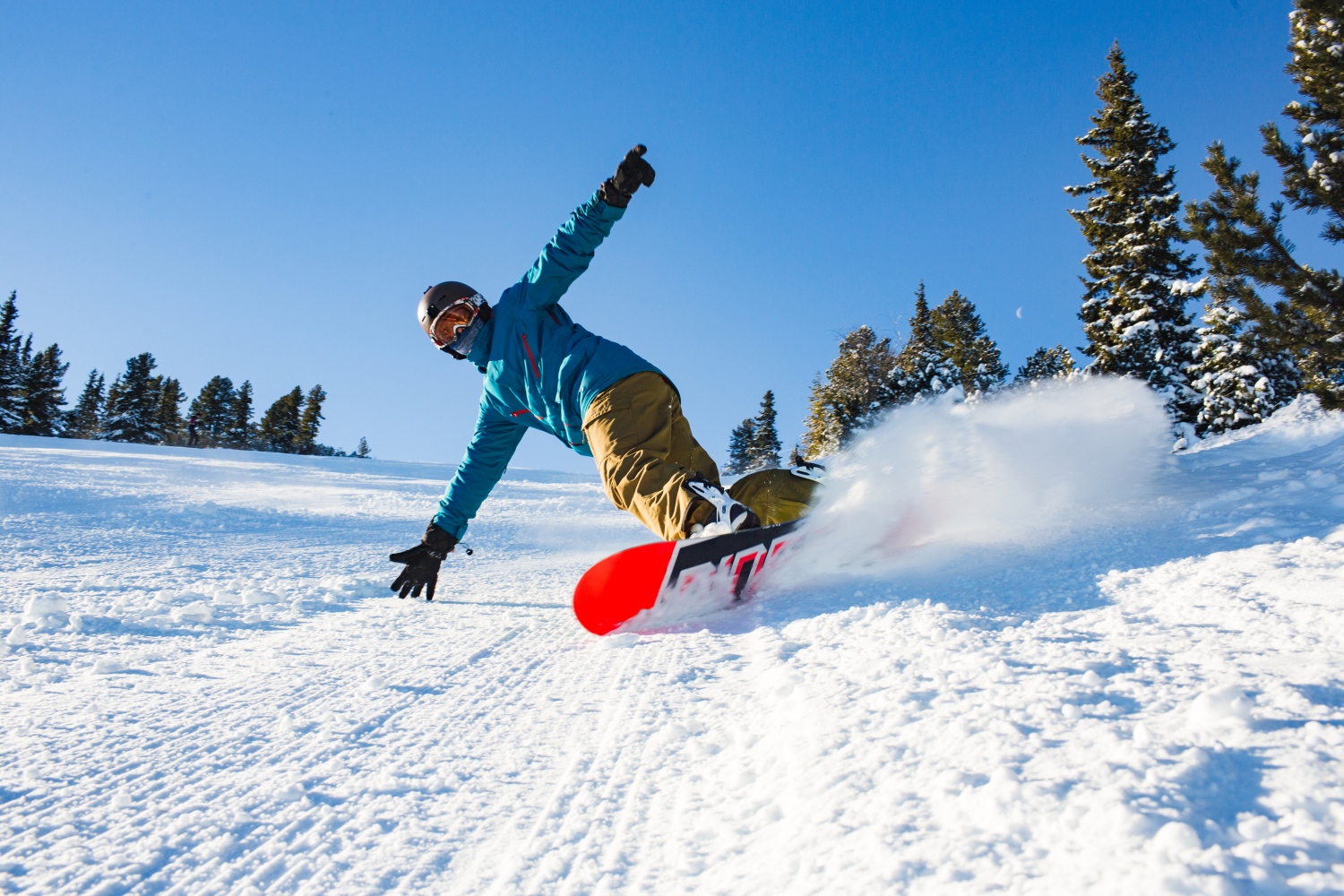 Man snowboarding and creating snowy dust cloud