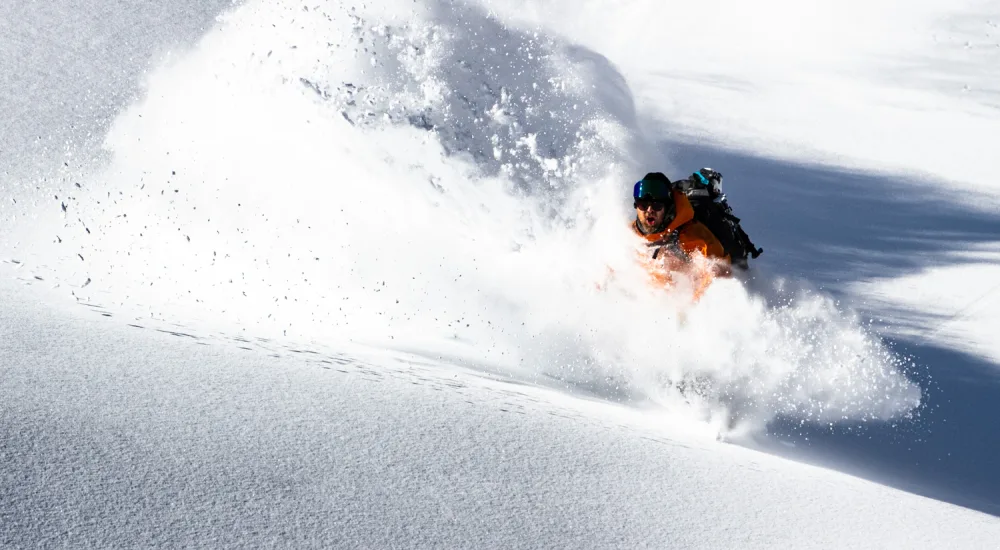 man coming through large snow dust cloud verbier credit tristan kennedy 1