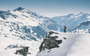 Skier looking out at snowy mountains SalzburgerLand CREDIT Daniel Wildey