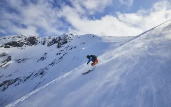 Skier riding down slope with snow blowing across plain Scottish Ski Touring CREDIT EdSmith WildSki22 HighRes 42