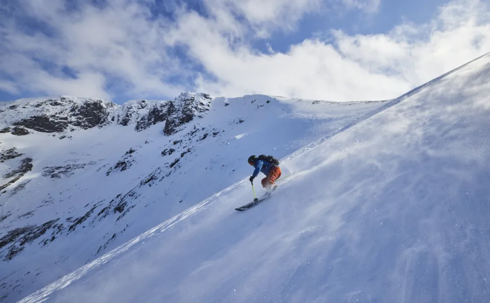Skier riding down slope with snow blowing across plain Scottish Ski Touring CREDIT EdSmith WildSki22 HighRes 42