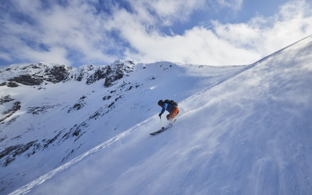 Skier riding down slope with snow blowing across plain Scottish Ski Touring CREDIT EdSmith WildSki22 HighRes 42