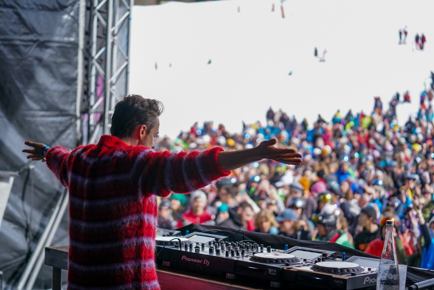 DJ playing on stage with blurred crowd in background_Rock The Pistes Festival Review