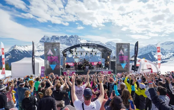 Crowds dancing to performers on stage with snowy mountains in background Rock The Pistes Festival Review CREDIT MATTHIEU VITRE RTP 2023